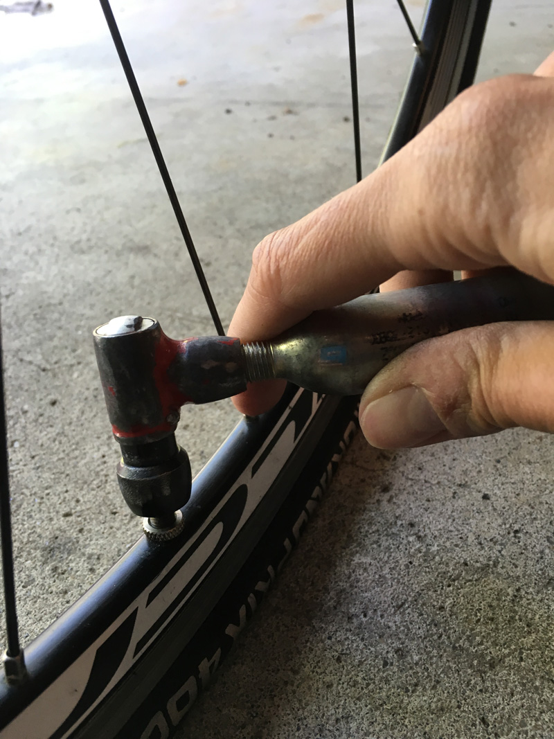 Using a C02 cartridge and inflator to get your tire inflated so you can continue on with your ride.
